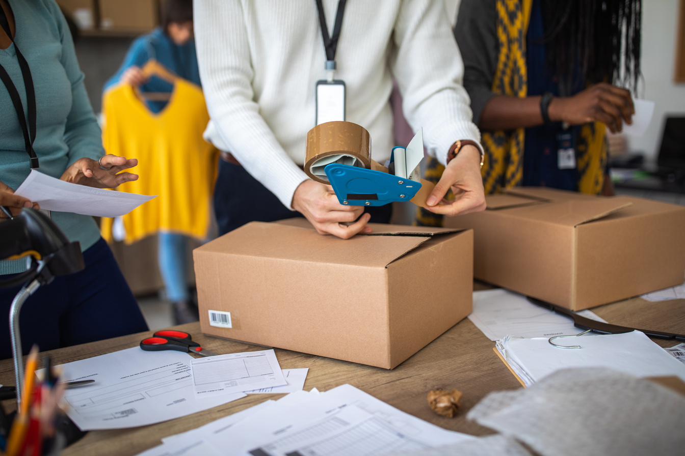 Workers packing merchandise for customer at office